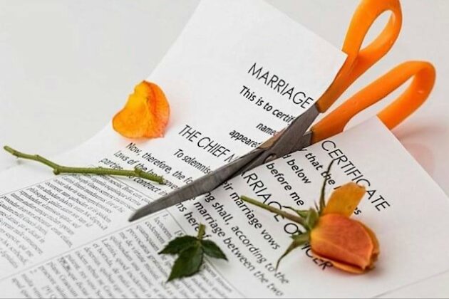 Marriage certificate being cut in half with orange handled scissors